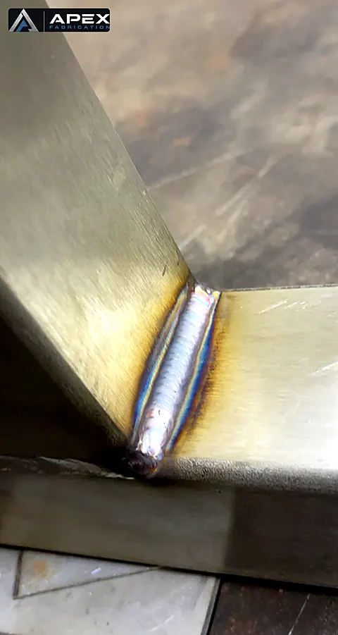 TIG fillet weld with heat tint at the corner joint of an angled stainless steel frame member