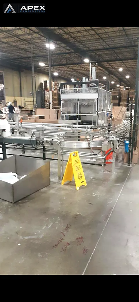 Stainless conveyor line and enclosed packaging machine installed on a bottling plant floor
