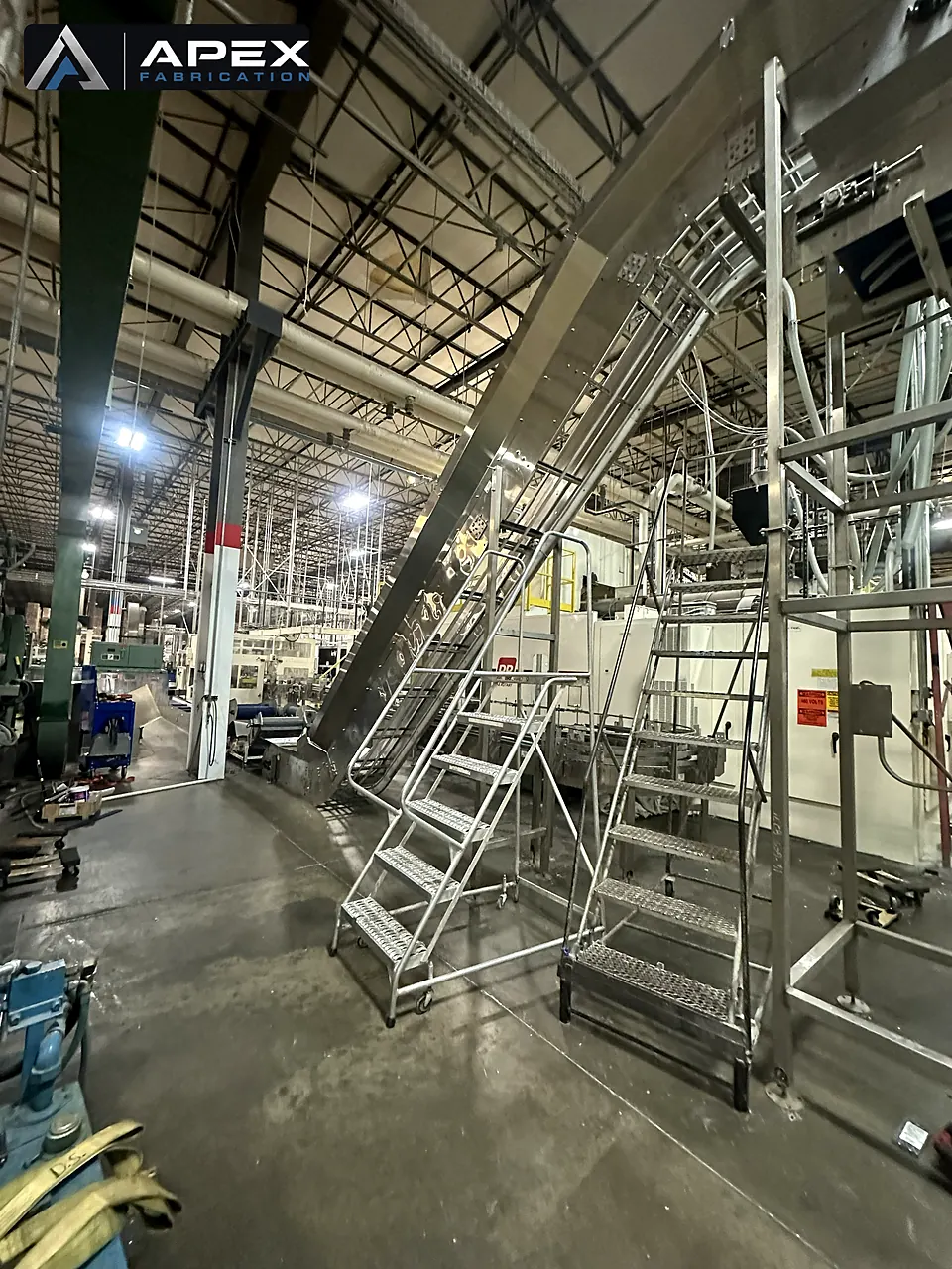 Aluminum crossover platforms and stair units installed over conveyor lines in a manufacturing plant