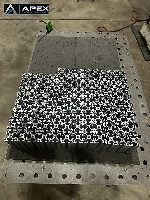 Bundle of precision-cut aluminum extrusion profiles for conveyor framing on a fixture table