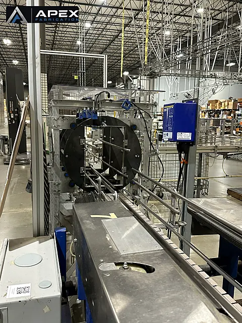 Orbital wrapping machine with large rotating ring and stainless infeed conveyor on a production line