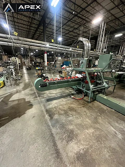 Single-purpose production machine with elevated chute installed on a manufacturing plant floor