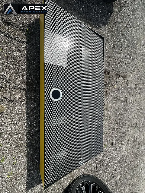 Expanded-metal grating deck and drain port on a yellow spill containment platform