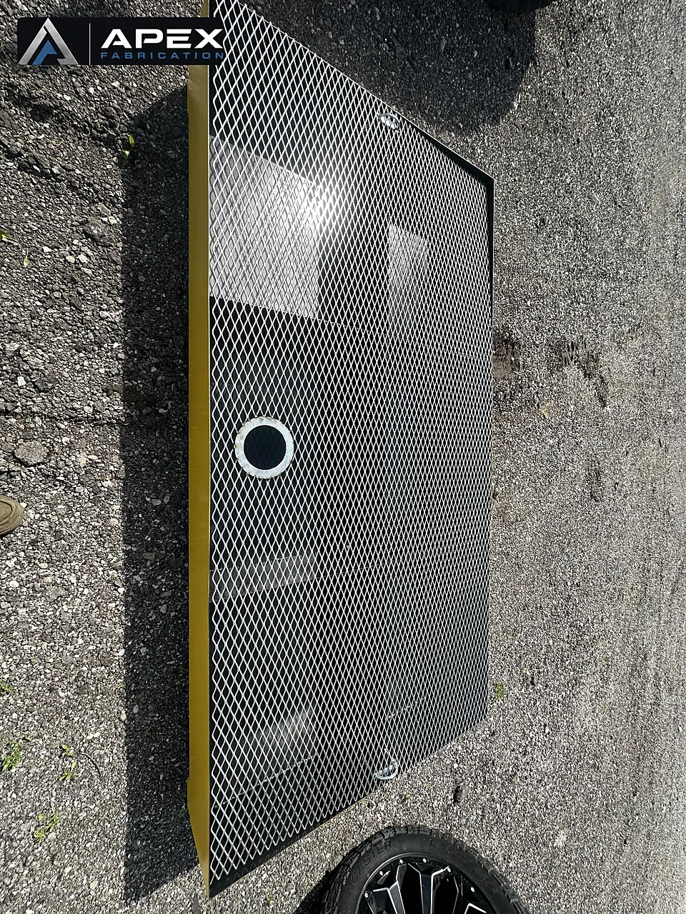 Expanded-metal grating deck and drain port on a yellow spill containment platform