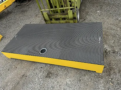 Yellow spill containment platform with black expanded-metal grating deck and drain fitting