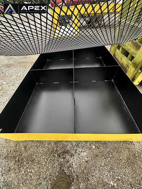 Black-coated interior compartments of a spill containment platform with grating removed