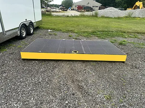 Finished yellow spill containment platform with black grating deck and center drain
