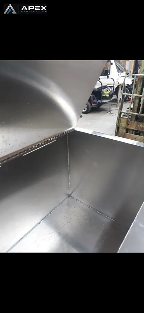 Interior of a fabricated stainless steel hopper showing clean seams and brushed panels