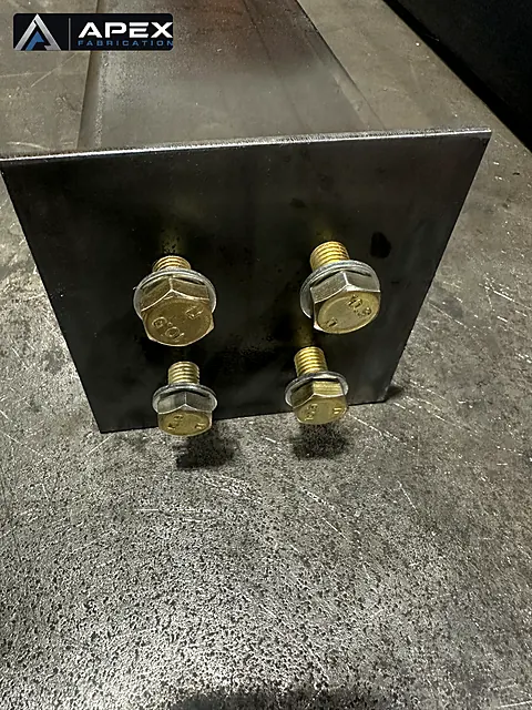 Base plate welded to a steel tube column with four plated bolts installed